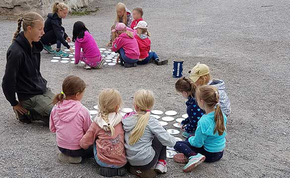 Naturskola med barn på grusstrand.